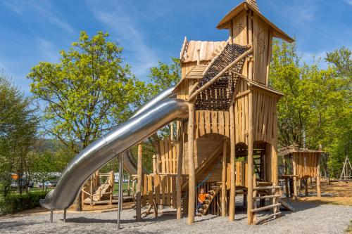 a slide in a wooden playground at Wirthshof Hotel & Chalets in Markdorf