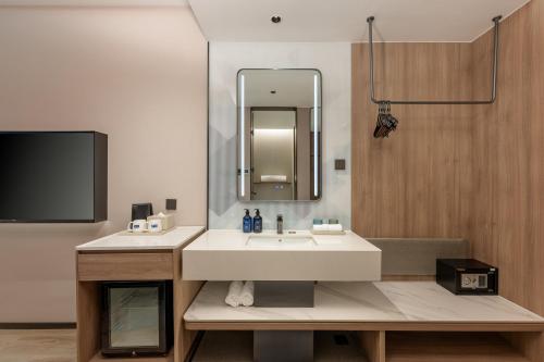 a bathroom with a sink and a mirror at Holiday Inn Express Shanghai Changyang Road by IHG in Shanghai