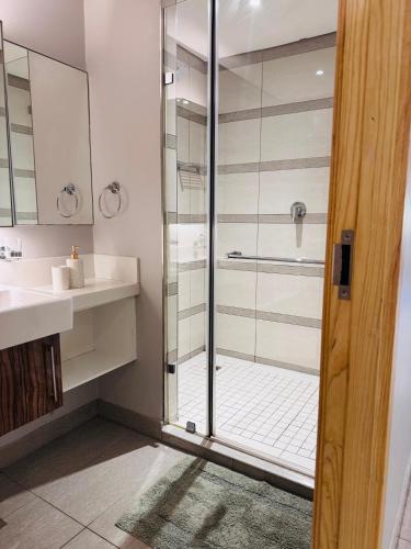 ダーバンにあるPearlviewのガラスのシャワーと洗面台を備えたバスルーム