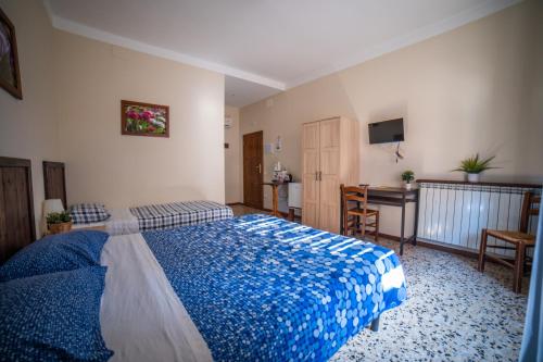 a bedroom with a blue bed and a desk at Affittacamere Al Passatore in Ravenna