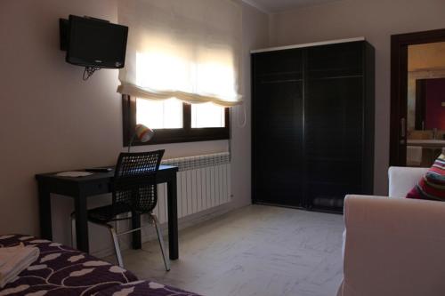 a room with a desk and a bed and a television at Allucant - Gallocanta in Gallocanta