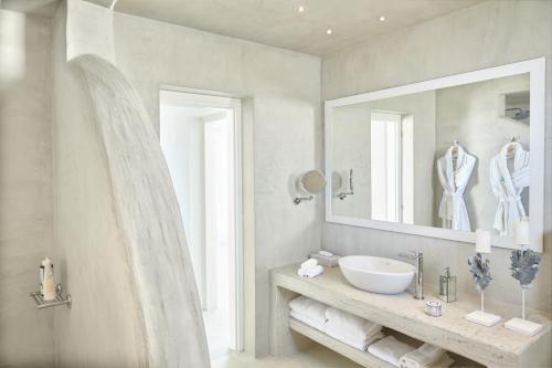a white bathroom with a sink and a mirror at Nafsika Estate in Megalokhori