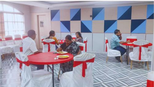 een groep mensen die aan tafels in een restaurant zitten bij Hotel Shaktiheritage Inn in Bhubaneshwar