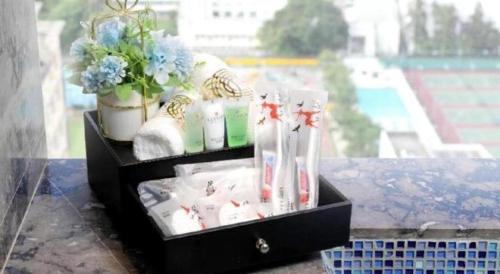 香港にあるElysion Place Hotel Causeway Bayの棚の上に置かれた歯ブラシと植物が入った黒い箱