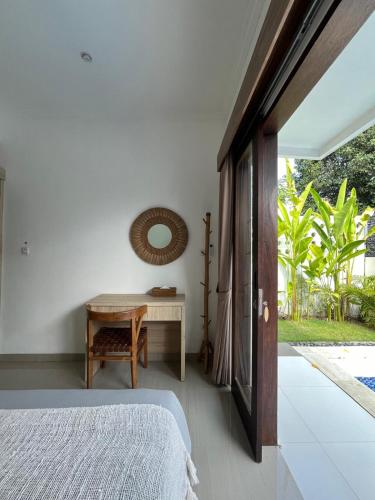 a bedroom with a bed and a desk and a table at Villa Kelle - Uluwatu Nusa Dua in Nusa Dua
