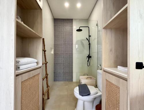 a bathroom with a toilet and a shower at Villa Kelle - Uluwatu Nusa Dua in Nusa Dua