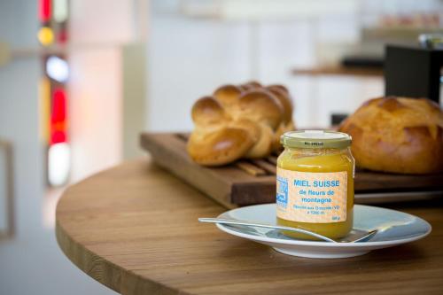 a table with a plate of bread and a jar of mustard at Hotel du Léman - Jongny in Vevey