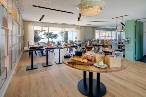a cafeteria with a table with bread and pastries on it at Hotel du Léman - Jongny in Vevey