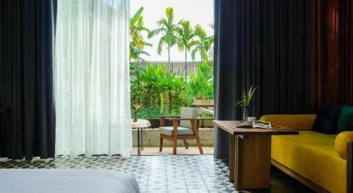 un salon avec un canapé jaune et une table dans l'établissement K.K inn Boutique Siem Reap, à Siem Reap