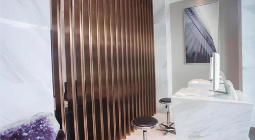 La salle de bains est pourvue d'un mur en bois avec deux tabourets et d'un bureau. dans l'établissement City Comfort Inn Zhanjiang Shimao Building Chikan Old Street, à Tchia-k'am