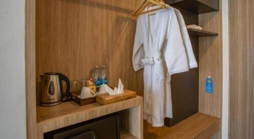 La salle de bains est pourvue d'un peignoir blanc accroché au mur. dans l'établissement Chewa Khong Hotel Nakhon Phanom, à Ban Tha Khwai