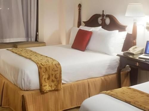 a hotel room with two beds and a phone at Hilgard House Westwood Village in Los Angeles