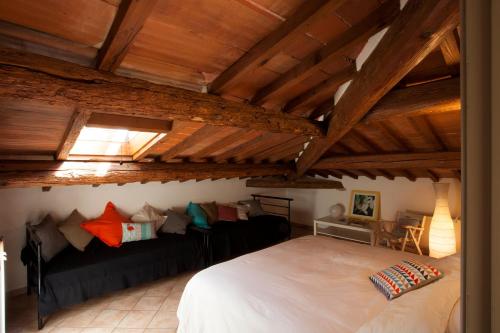 um quarto com uma cama branca e um sofá preto em Casa Cosi Masaccio em Florença