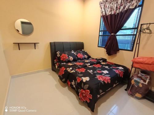 a bedroom with a bed and a window at Teratak Saharah Homestay in Port Dickson