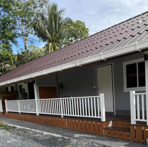 a house with a white porch and a roof at Pradu House 