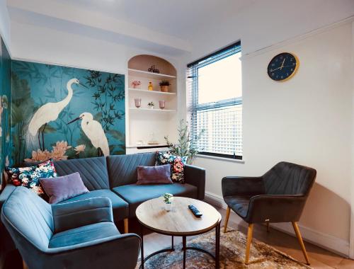 a living room with a blue couch and a table at Home away from home-business & leisure travellers in Northampton