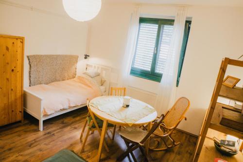 a small bedroom with a table and a bed at Bolgárkert Family House in Budapest