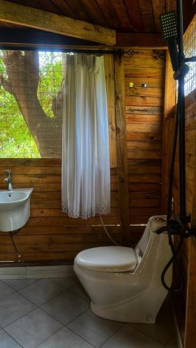 a bathroom with a toilet and a sink at Amoy River Lodge in Moshi