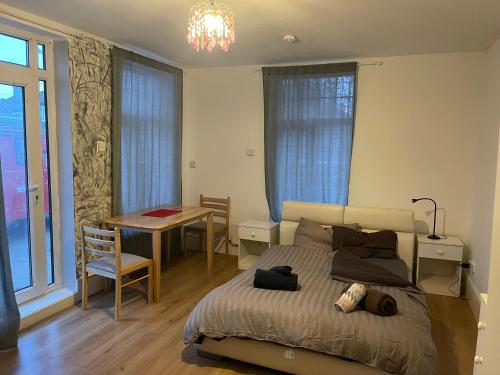 a bedroom with a bed and a table and a desk at Large double room next to Elisabeth Line in Abbey Wood
