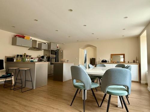 a kitchen and living room with a table and chairs at L'escale Granvillaise in Granville