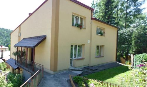 ein großes Haus mit zwei Fenstern und einem Balkon in der Unterkunft Apartament w Dolinie Popradu in Piwniczna-Zdrój