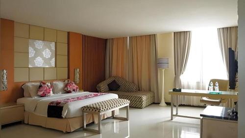 a hotel room with a large bed and a couch at Kedaton Hotel in Bandung