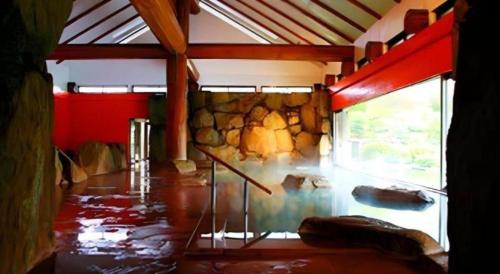 a room with a room with a stone wall at Hotel Tokoen in Yonago
