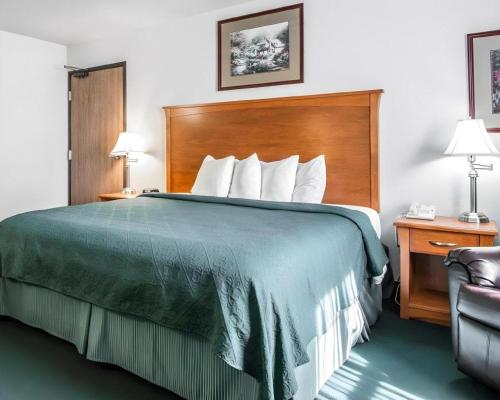 Cette chambre comprend un lit avec une couverture verte. dans l'établissement Quality Inn Kearney - Liberty, à Kearney