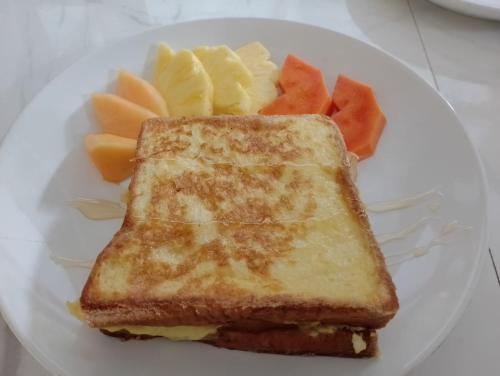 Pondok Hari Baik في Balian: طبق أبيض مع شطيرة جبن مشوي وفاكهة