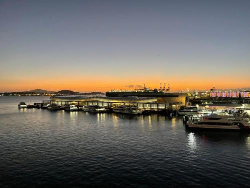 a dock with boats in the water at sunset at Princes Wharf - Spectacular Couple Getaway in Auckland