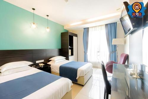 Kampong Nipah PanjangにあるIn Trend Hotelのベッド2台とガラスのテーブルが備わるホテルルームです。
