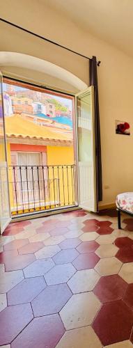 an empty room with a balcony with a large window at Appartamento vacanze Le rose in Bosa