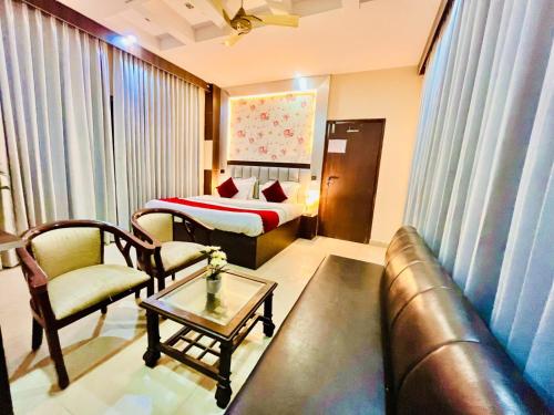 a hotel room with a couch and a bed at Hotel Ramawati, A Luxury Hotel & Resort, Haridwar in Haridwār