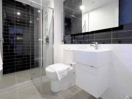 a bathroom with a toilet and a sink and a shower at High level on 42th floor 2BR 1BA Balcony Pool in Melbourne