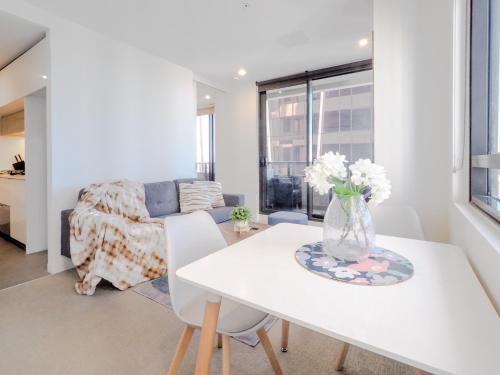 a living room with a white table and a couch at High level on 42th floor 2BR 1BA Balcony Pool in Melbourne