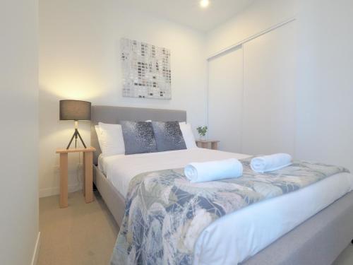 a bedroom with a bed with blue pillows on it at High level on 42th floor 2BR 1BA Balcony Pool in Melbourne