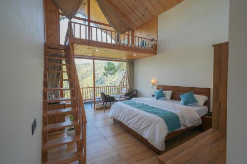 a bedroom with a large bed and a staircase at The Trishul Vista in Mukteshwar