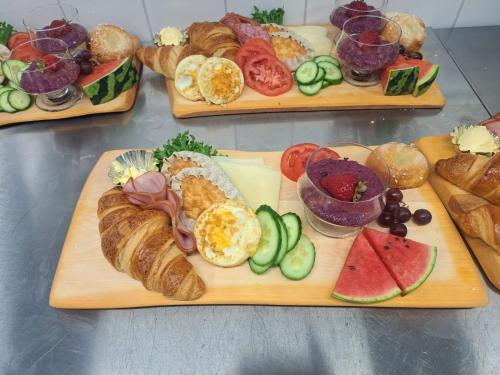 a bunch of different types of bread and pastries on cutting boards at Hotelli Savonlinna in Savonlinna