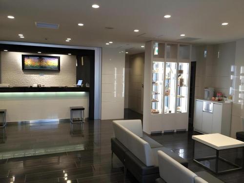 a lobby with a waiting room with a couch and a table at JR-EAST HOTEL METS NAGAOKA in Nagaoka