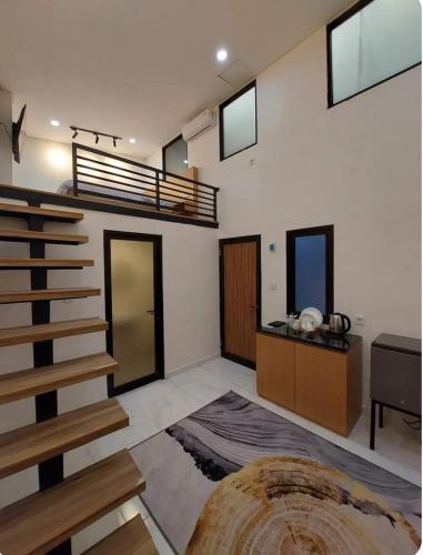 a living room with a spiral staircase and a table at The W Residence in Jakarta
