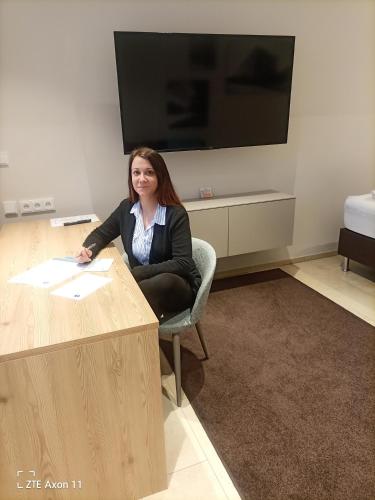 a woman sitting at a desk in a room at TT Aparthotel Neuhofen in Neuhofen an der Krems