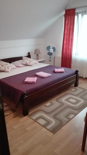 a bedroom with a large bed with pink towels on it at Guest House Adrijana in Seliste Dreznicko