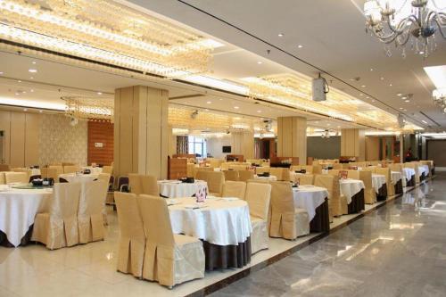 中山市にあるZhongshan Da Dong Yu Hotelの白いテーブルと椅子が置かれた宴会場