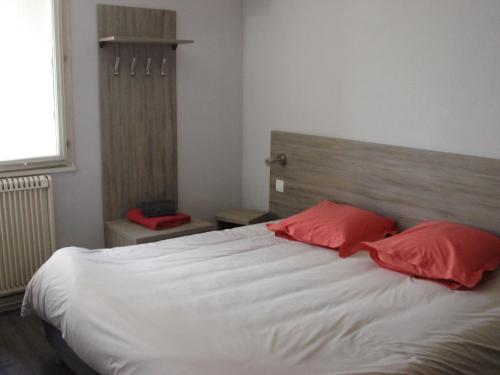 パルトネーにあるL'envers du Castilleのベッドルーム1室(大型ベッド1台、赤い枕2つ付)