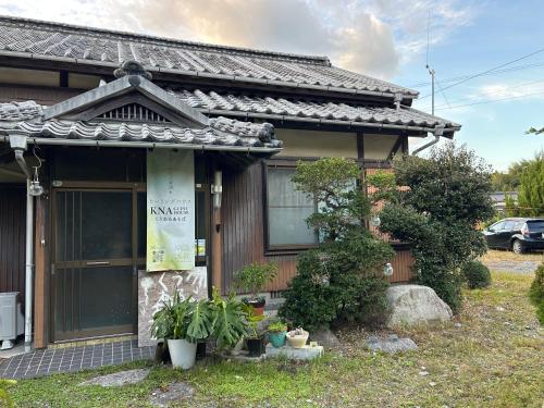 a small house with plants in front of it at KNA healing house くうねるあそぼ ペットと泊まれる宿 自炊ok広々と大らかな自然の中で過ごしたい方に in Suo Oshima