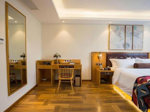 Cette chambre comprend un lit et un bureau avec une chaise. dans l'établissement James Joyce Coffetel· Hefei Anhui Agricultural University, à Hefei