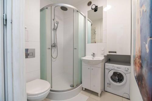 a bathroom with a shower toilet and a sink at Apartly - Apartament Wyszyńskiego z loggią in Szczecin