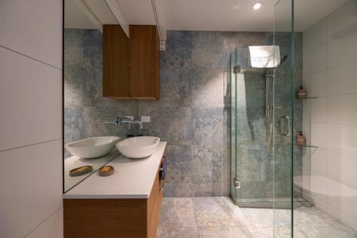 Un baño con dos lavabos y una ducha. en Aspiring View Apartments, en Wanaka
