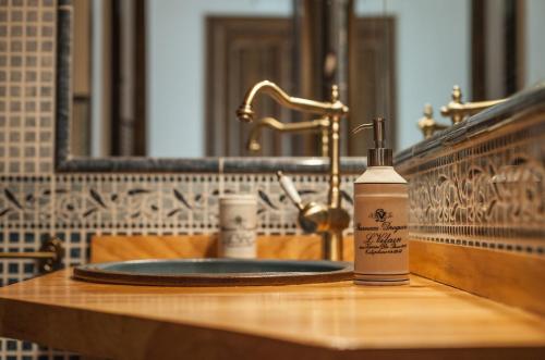 una botella de jabón en el lavabo del baño en Apartamentos Rurales Millan, en La Mata de los Olmos