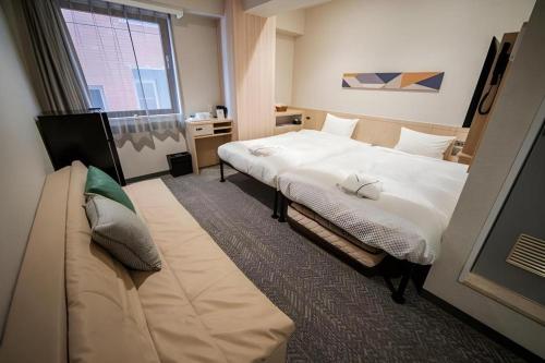 a hotel room with a bed and a couch at Hotel IL FIORE Kasai ANNEX in Tokyo